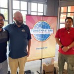 Hovey, Patrick, and Cliff pose with the District 100 banner